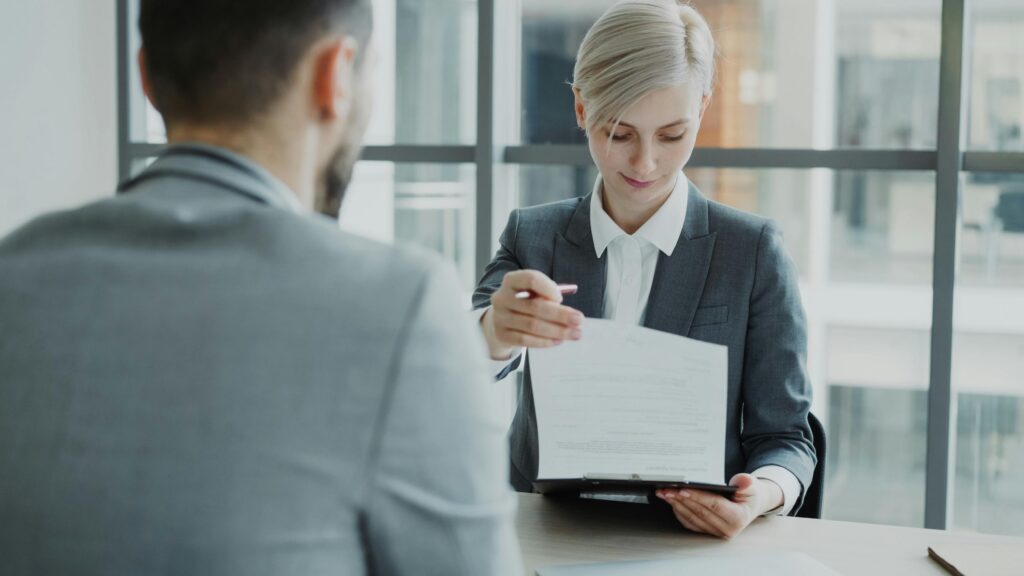 Business professionals reviewing a contract in a modern office setting.